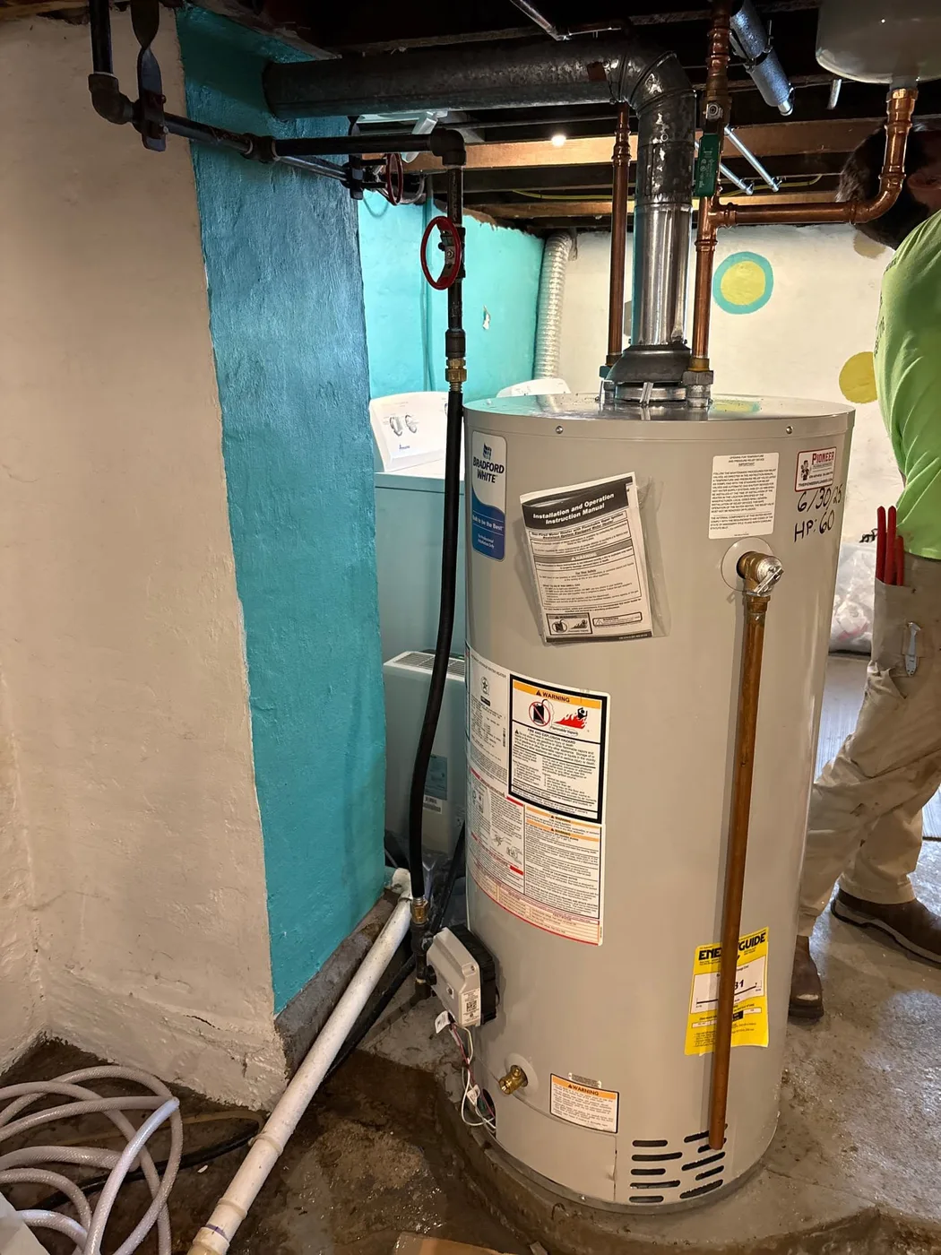 Pioneer technician beside an installed residential water heater